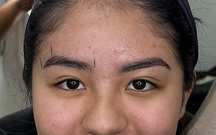 Cejas de una clienta con las marcas del diseño trazadas antes de depilar.